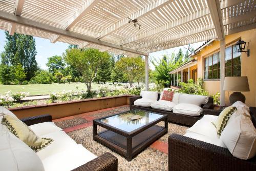 a patio with white furniture and a glass table at Viña La Playa Hotel & Winery in Santa Cruz