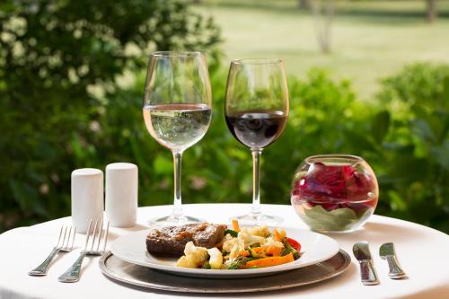 a table with a plate of food and two glasses of wine at Viña La Playa Hotel & Winery in Santa Cruz