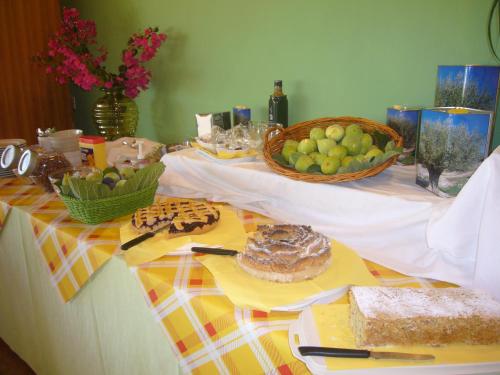 a table with food and a basket of fruit at Villa Vacanze Paradiso - Oasi di Tranquillità con Piscina e Giardino a 10 min dal mare in Neviano