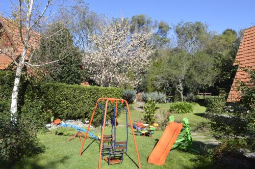 un jardín con un parque infantil con un tobogán en Cabañas Bosque Encantado en Merlo
