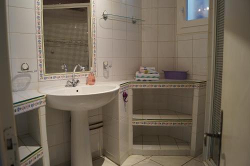 une salle de bain avec un lavabo et un miroir dans l'établissement Appartement en Provence, à Aubagne