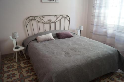 une chambre avec un grand lit avec deux oreillers dessus dans l'établissement Appartement en Provence, à Aubagne