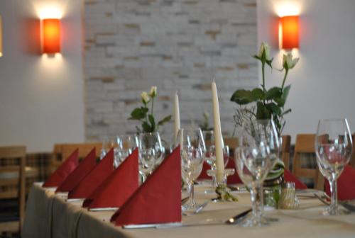 a table with wine glasses and red napkins on it at Landgasthof Linkenmühle in Hornbach