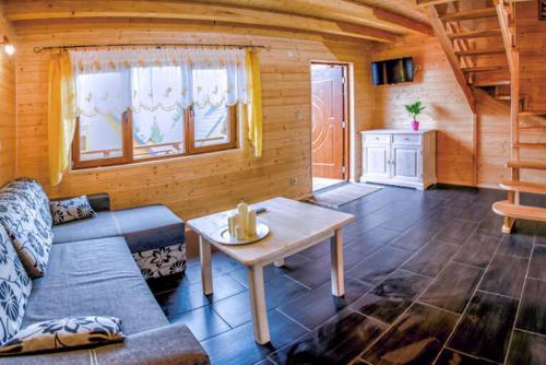 a living room with a couch and a table at Domki u Piotra in Solina