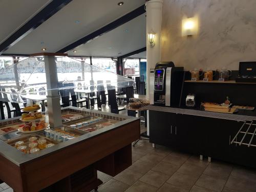 a restaurant with a buffet line with food on display at Hôtel Port Beach in Gruissan
