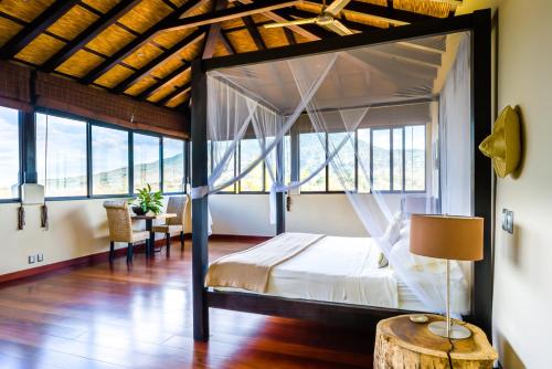1 dormitorio con 1 cama grande y suelo de madera en El Respiro Ecolodge en Granada