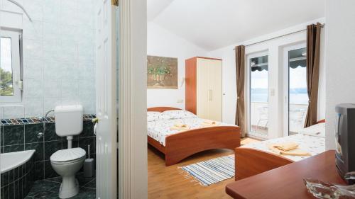 a bedroom with two beds and a bathroom at House Coko in Baška Voda