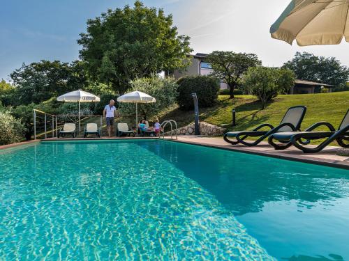 una piscina con sillas y sombrillas junto a una casa en Villa Beatrice, en Verona