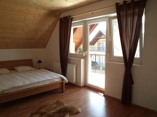 una camera da letto con un letto e una grande finestra di Balaton Villa a Gyenesdiás