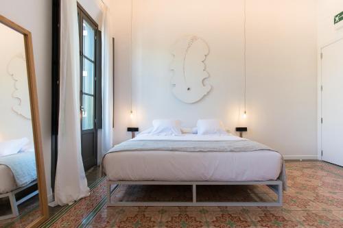 a bedroom with a bed and a large mirror at Sodium Boutique Hotel in Ciutadella