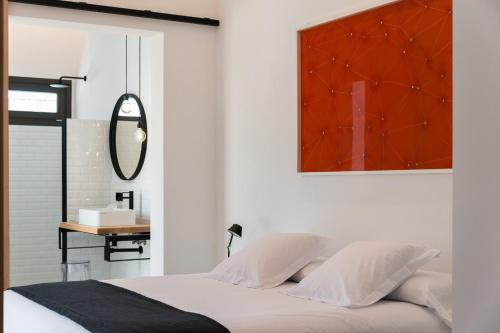 a bedroom with a bed with a mirror on the wall at Sodium Boutique Hotel in Ciutadella