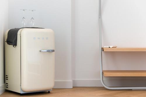 an old white refrigerator sitting next to a wall at Sodium Boutique Hotel in Ciutadella
