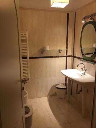 a bathroom with a sink and a toilet and a mirror at Affittacamere Villa Wilson in Rome