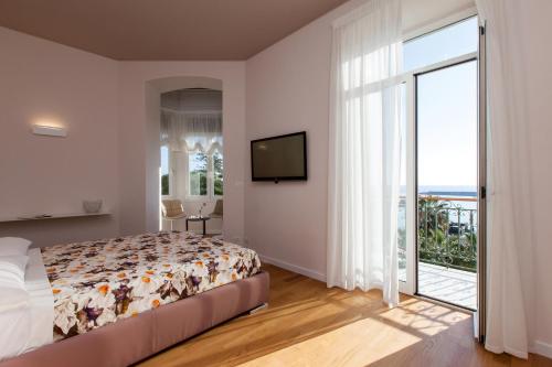 - une chambre avec un lit et une grande fenêtre dans l'établissement Casa del Mare, à Sanremo