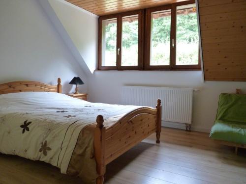 VilléにあるLes Cerisiersのベッドルーム1室(木製ベッド1台、窓2つ付)