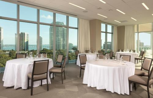 a conference room with tables and chairs and large windows at Novotel Miami Brickell in Miami