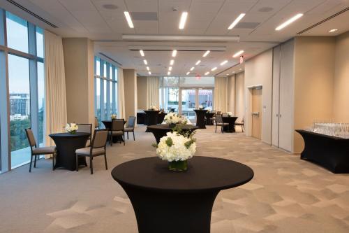 a waiting room with tables and chairs and flowers at Novotel Miami Brickell in Miami