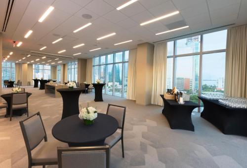 a waiting room with tables and chairs and windows at Novotel Miami Brickell in Miami