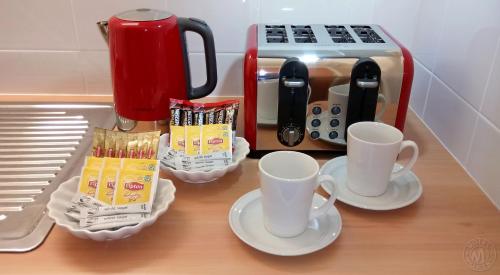 a counter with two cups and a coffee maker at Millicent Motel in Millicent