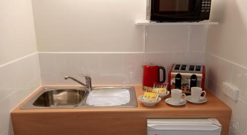 a kitchen counter with a sink and a microwave at Millicent Motel in Millicent