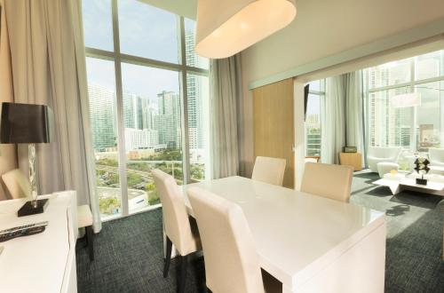 
a hotel room with a dining room table and chairs at Novotel Miami Brickell in Miami
