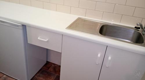 a kitchen with white cabinets and a sink at Millicent Motel in Millicent
