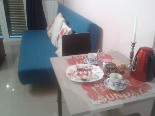 a table with a laptop on top of a blue chair at Super 36sqm Junior Suite in luxurious picturesque area in Piraeus