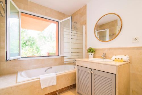a bathroom with a tub and a sink and a mirror at Golden Mile Oasis in Marbella