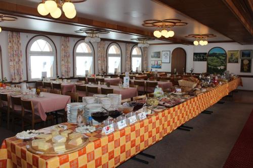 a long table in a room with tables and chairs at Hotel Hulfteggpass in Mühlrüti