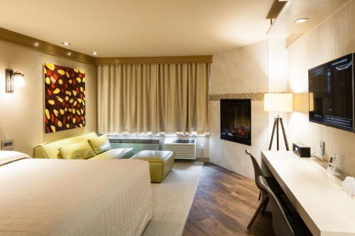 une chambre d'hôtel avec un lit et un canapé dans l'établissement Le Chabrol Hotel & Suites, à Montréal