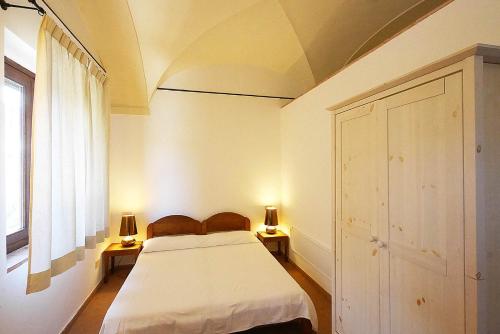 a bedroom with a bed and two lamps on two tables at Poggio di Sole in Lacona
