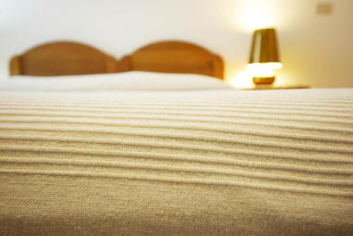 a bed with a white blanket and a lamp at Poggio di Sole in Lacona