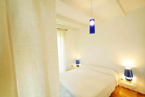 a bedroom with a white bed and a window at Poggio di Sole in Lacona