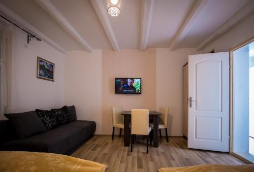 a living room with a couch and a table at Dve kuce pored jezera in Palić