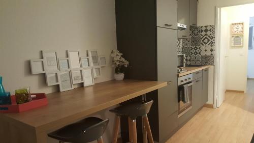 - une cuisine avec un comptoir et deux tabourets dans l'établissement Studio des Anges, à Villeneuve-Loubet