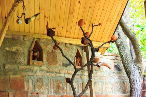a wooden ceiling with a tree branch in front of a brick oven at Amiran's Lake in Tbilisi City