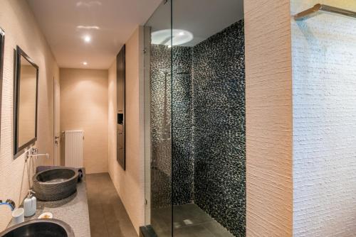 een badkamer met een glazen douche en een bad bij White Villas in Karavomylos