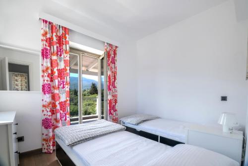 een kamer met twee bedden en een raam bij White Villas in Karavomylos