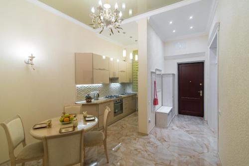 a kitchen with a table and chairs and a dining room at Vip Apartment na Derebasovskoi in Odesa
