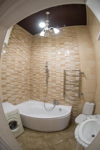 a bathroom with a tub and a toilet and a sink at Vip Apartment na Derebasovskoi in Odesa