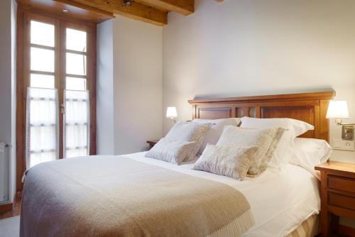 Un dormitorio con una gran cama blanca con almohadas. en Besiberri by FeelFree Rentals, en Garós