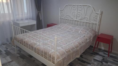 コンスタンツァにあるTourist's Delight Apartmentのベッドルーム(白いベッド1台、赤いスツール付)