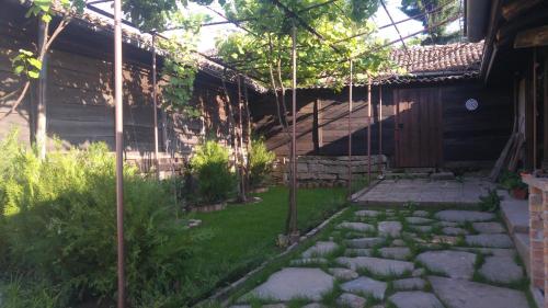 a garden with a stone walkway next to a building at Guest House Strumena in Elena