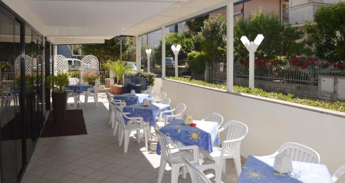 a row of tables and chairs with blue table cloths at Hotel Karin in Rimini
