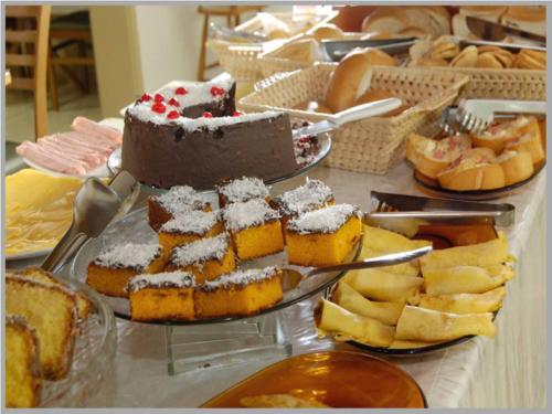 un tavolo sormontato da una torta e altri dessert di Cometa Plaza Hotel a São Luís Gonzaga