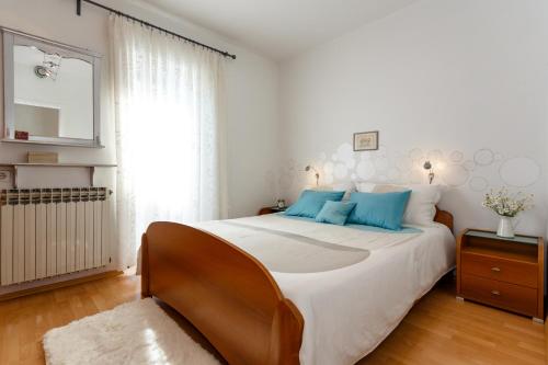 a bedroom with a large bed with blue pillows at Apartments Mia in Malinska