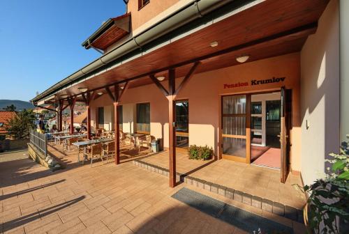 a building with a patio with tables and chairs at Penzion Krumlov - Massage studio in Český Krumlov