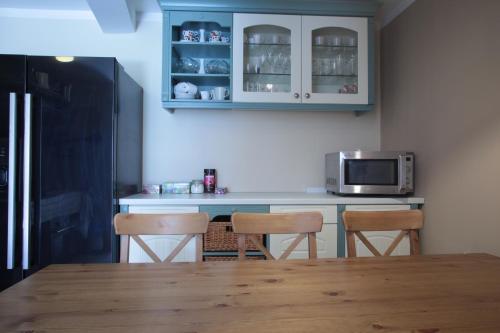 a kitchen with a table and chairs and a microwave at Hostel Adriatic Piran in Piran