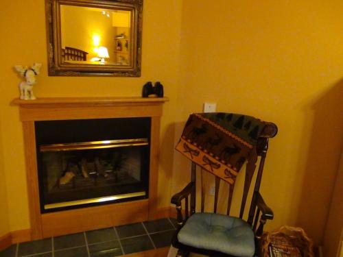 a room with a fireplace and a mirror and a chair at Berry Springs Lodge in Sevierville