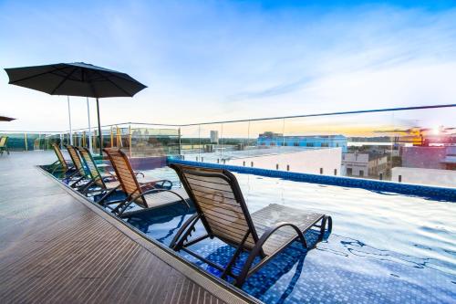 a row of chairs sitting on the edge of a swimming pool at Oscar Hotel Executive in Porto Velho